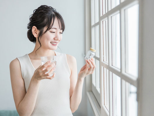 ビタミンを服用する女性イメージ