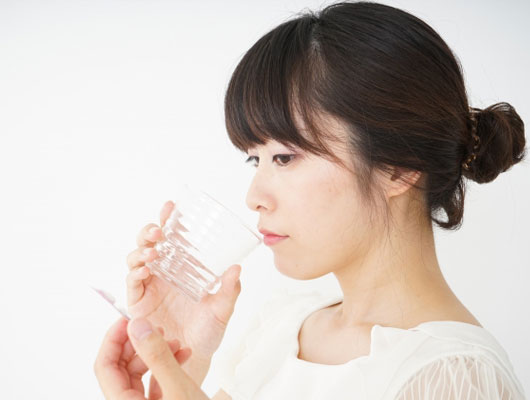 内服をする女性イメージ